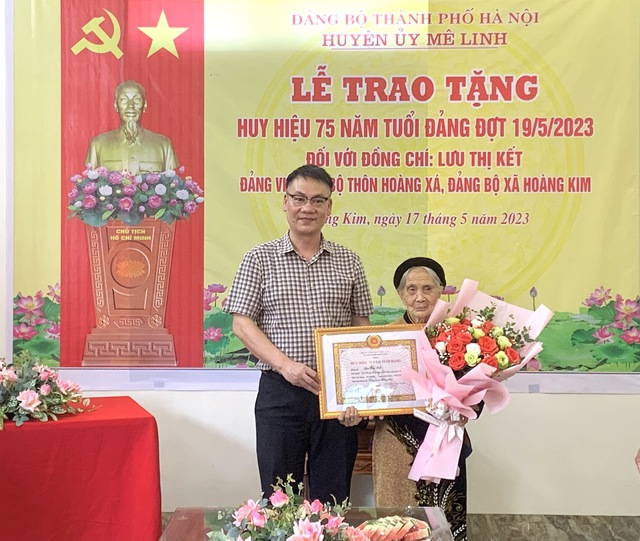 Phó Bí thư Thường trực Huyện ủy Nguyễn Anh Tuấn trao tặng Huy hiệu 75 năm tuổi Đảng cho đồng chí Lưu Thị Kết - Ảnh 1.