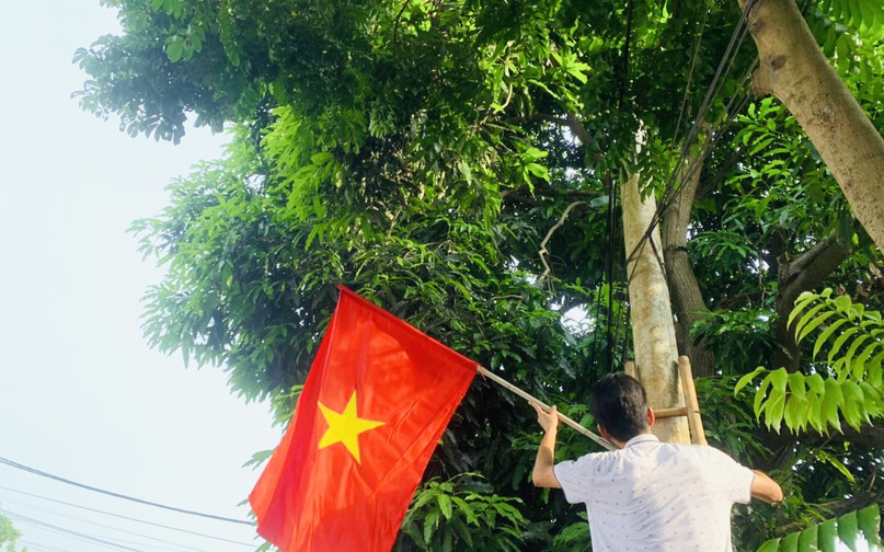 Người dân xã Thanh Lâm phấn khởi treo cờ tổ quốc chào mừng Quốc khánh 2/9.