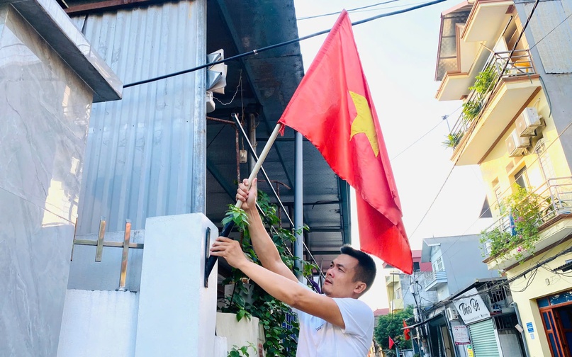 Người dân thị trấn Quang Minh treo cờ Tổ quốc chào mừng kỷ niệm 70 năm Ngày Giải phóng Thủ đô.